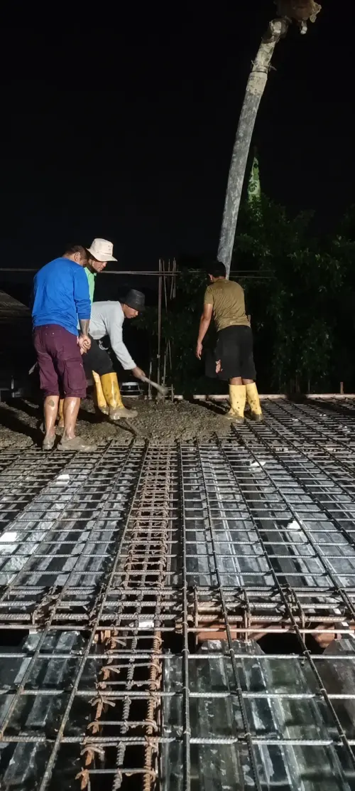 Pekerja meratakan cor